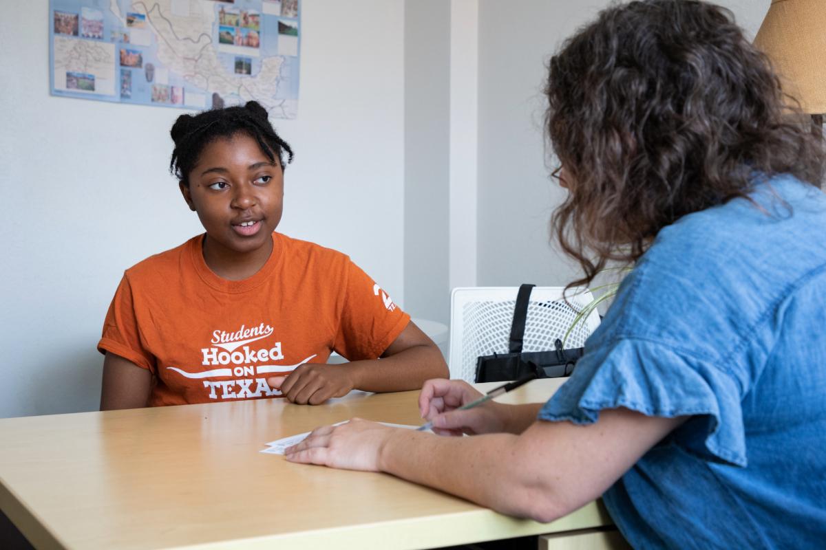Student at a desk talking with someone