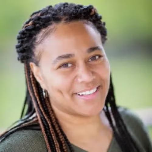 Headshot of Pam with blurred green background