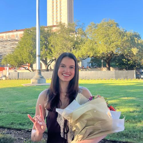 Christina with flowers and hook 'em, tower in the background