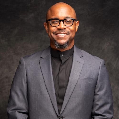 Dr. Jones headshot in suit with dark background