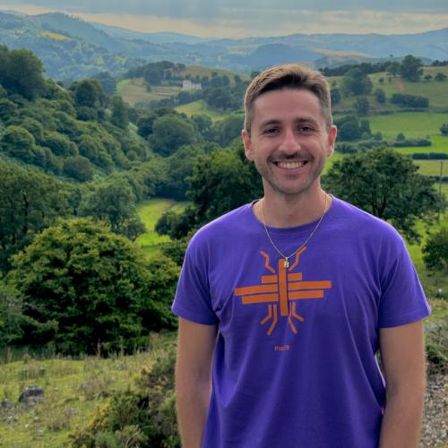Vassilis standing with rolling hills in the background